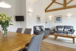 Large living/dining area at The Plovery at Church Farm Cottages in East Yorkshire. The room features high ceilings and traditional beams.