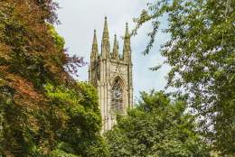 The top of the Priory Church in Bridlington emerging through tree tops.