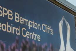 A sign saying RSPB Bempton Cliffs Seabird Centre with an image of two gannets