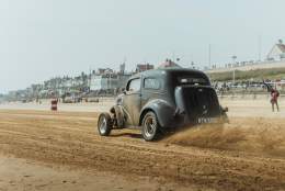 A vintage car racing along Bridlington beach