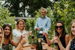 A man and women toasting with glasses of wine at Albury Vineyard