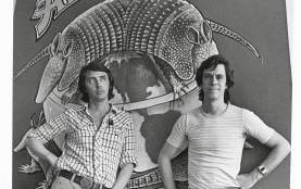 Black and white photo of two men in front of Armadillo World Headquarters sign