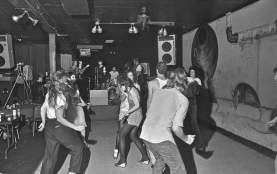 Black and white historic photo of small crowd dancing in front of band at Rauls in Austin Texas