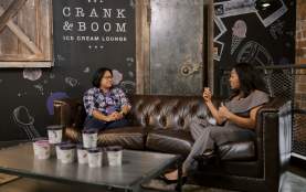 Two women sitting on couch facing each other during an interview.