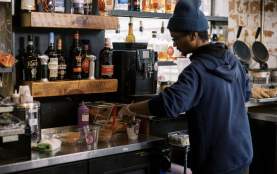 Staff member scooping ice cream into a cup at ice cream lounge