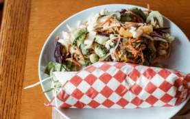 A burrito and salad on a plate.