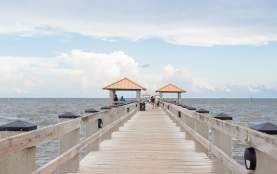 Seascape. Wooden pier with gazebos with orange roofs. Summer background. Ken Combs Pier, Gulfport, MS, USA