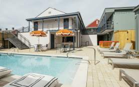 private backyard patio with umbrellas, sun bathing chairs, and luxury pool