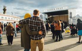 two people embrace in front of a stage at outdoor music festival