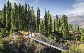 A couple ride on bikes over the Arrow River Bridges Trail