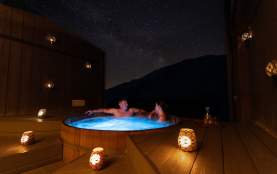 A couple enjoy a private spa at Onsen Hot Pools in Arthurs Point on a clear night