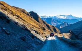 Tesla driving down Skippers Road with mountains in background