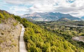 A couple of friends walking up the Tobin's Track in Arrowtown with views of the Whakatipu Basin and The Remarkables