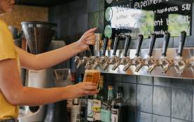 A staff member pouring a brew on tap at b.social Wānaka