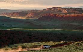 Vehicle driving on dirt road amongst Wyoming landscape