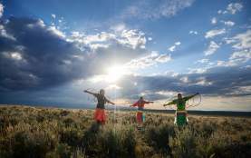 Women under cloudy sky in prairie field