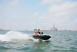Two girls on a jet ski riding across the ocean