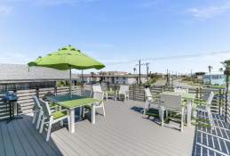 Overview of a deck with two green tables and a green umbrella