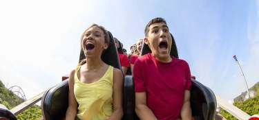 young couple having fun riding a roller coast in Cincinnati