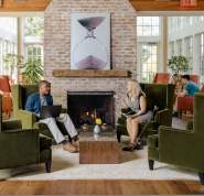 Two people sit across from one another discussing a presentation.