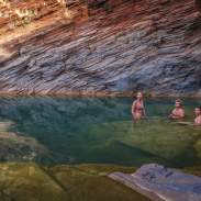 Three people in the water at Hamersley Gorge, Karijini National Park
