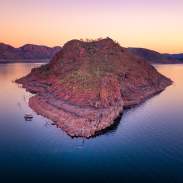View of an island in Lake Argyle with a boat moored alongside.