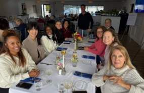 A group of people are seated together at a long table.