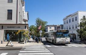 A Bee-Line Bus pass through the town of Rye where the streets are lined with shops and restaurants.