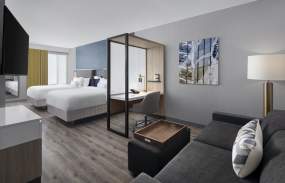 A hotel room with two beds and a seating area with coach.