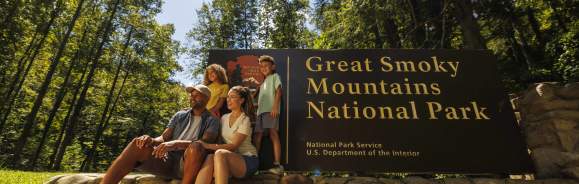 family in front of Smokies sign