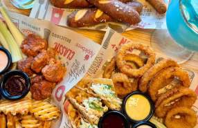 Assortment of Applebee's appetizers including chicken wings, mozzarella sticks, pretzels, onion rings, tacos, and waffle fries.