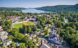 An aerial photo of Cooperstown during summer with a baseball field and the lake.