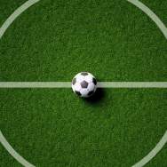 A soccer ball sits at the center circle on a soccer pitch.