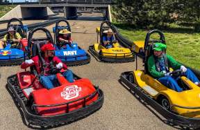 Red, blue, and yellow go-karts on a track at sprots world amarillo