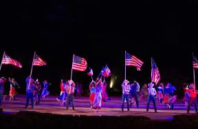Actors on holding texas flags on stage