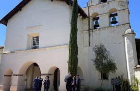San Juan Bautista Mission. People stand in front of the Mission entryway and Bell Tower.