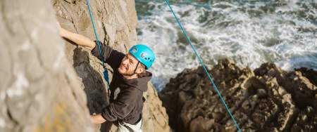 Man abseiling along coastal cliffs