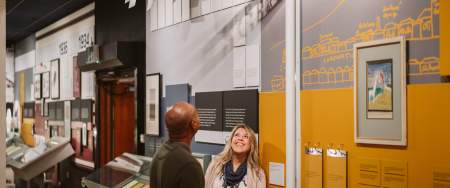 Couple exploring the Dylan Thomas Centre exhibition in the dylan thomas centre