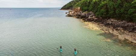 A drone shot of two people kayaking in Oxwich