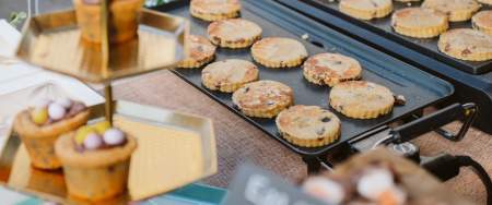 Welsh cakes cooking on a griddle at a local produce market.