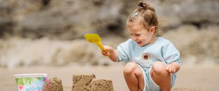 Small girl making sandcastles on the beach