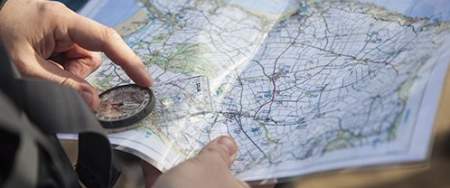 person holding a compass and a map