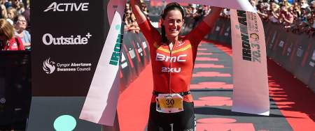Winner of the Swansea Ironman holding the finishing ribbon