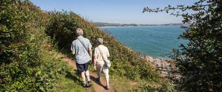 Older couple walking on the coastal path at Oxwich.