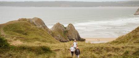 Walkers heading towards Three Cliffs Bay in the distance.