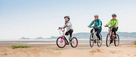 A family cycling on Swansea Bay