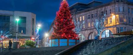 Christmas tree lit up at night in Castle Square in Swansea