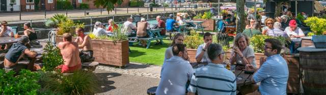 People sitting outdoors under the sun by The Ostrich pub in the Redcliffe area of Bristol - credit Mahtola Eagle
