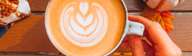 Overhead view of cup of coffee with fall leaves
