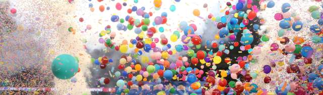 Balloons and smoke falling over football field in celebration.